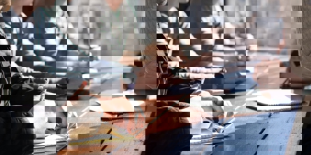 Folk sidder på en bænk og tager noter